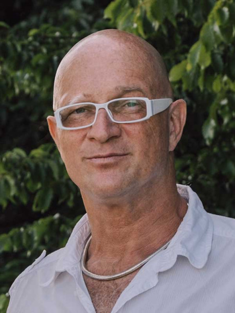 Bjørn Thorsten Leimbach - Profilbild von einem Mann mit Glatze, weißer Brille, weißes Hemd in der Natur