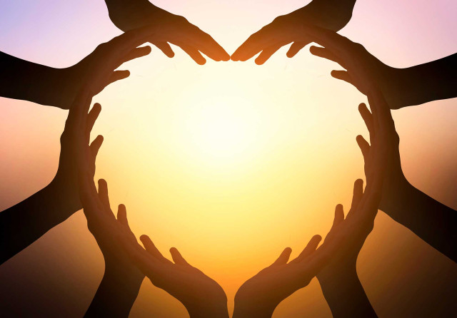 Trainings / LoveCreation Jahrestraining - viele Hände formen sich gemeinsam zu einem Herz durch das die Sonne scheint