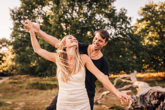 Body & Soul Seminar - Mann und Frau balancieren lachend über Baumstamm